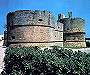 La torre a destra dell’ingresso e in secondo piano la terza torre, in una foto scattata prima degli scavi che hanno liberato le torri dal terreno circostante, riportandole alla loro altezza originaria