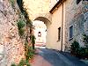 L’erta salita che porta all’ingresso della piazza centrale del borgo. Nella luce dell’arco si scorge il campanile-torre della chiesa di San Bartolomeo.